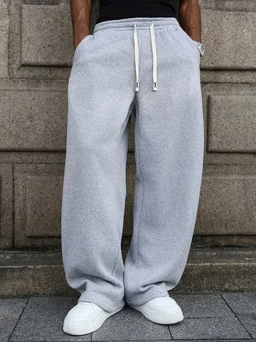 Calças de moletom masculinas, de corte largo e estilo casual, com cintura elástica e cordão duplo, detalhes em rebites, tecido de malha com efeito drapeado, corte folgado, bolsos nas costas laterais, calças compridas versáteis para uso urbano.